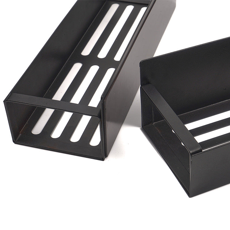 Two black metal trays with slotted design on a white background